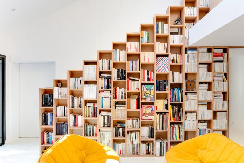 strakke witte trap met open houten boekenkast 