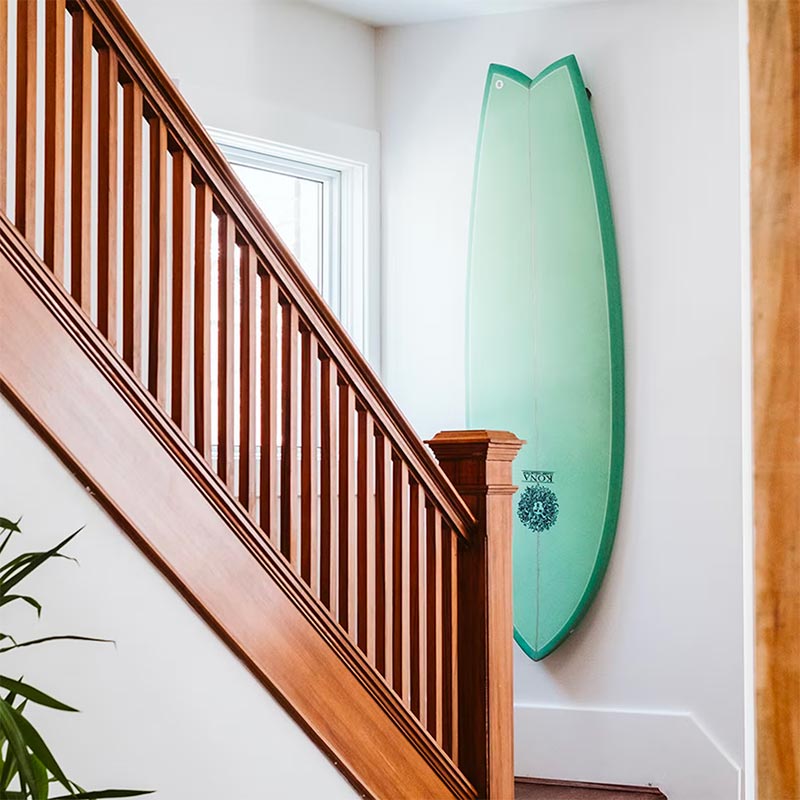 Surfboard ophangen aan de muur bij de trap
