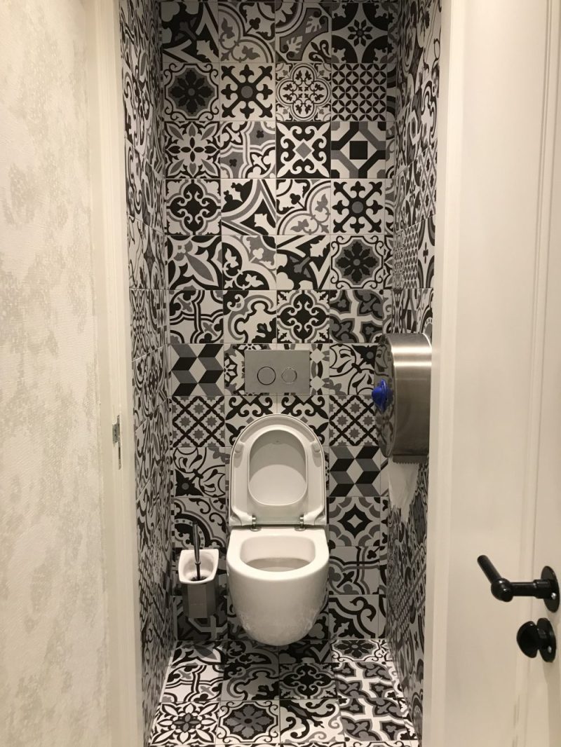 toilet ontwerp met patchwork tegels en betonstuc