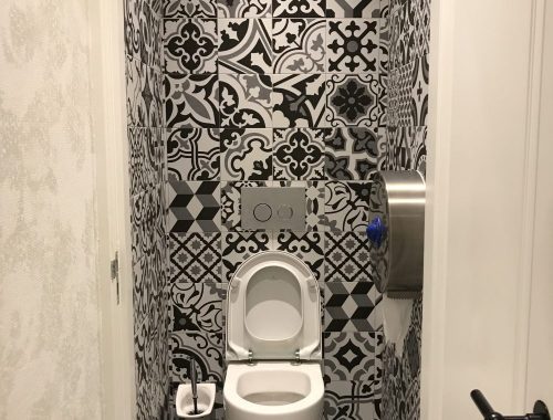 Toilet ontwerp met patchwork tegels en betonstuc