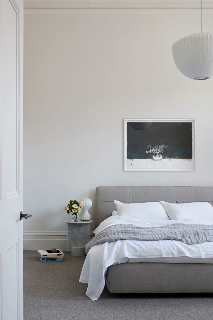 Deze prachtige slaapkamer, een ontwerp van Robson Rak, combineert lichte muren met grijze vloerbekleding. Het grijze bed past er perfect bij. | Fotografie: Shannon McGrath