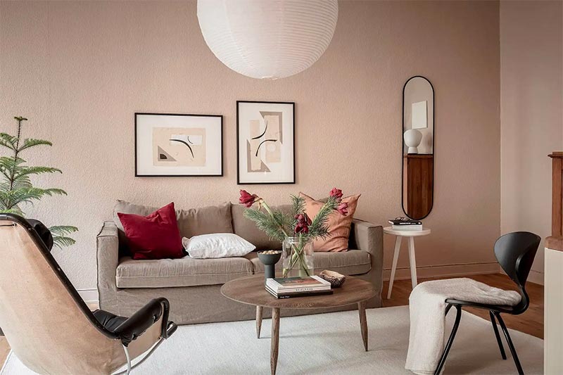 Deze woonkamer is volledig geschilderd in tinten rood, nuderoze, warm beige en terracotta - het werkt super mooi en voegt veel warmte toe aan dit interieur.