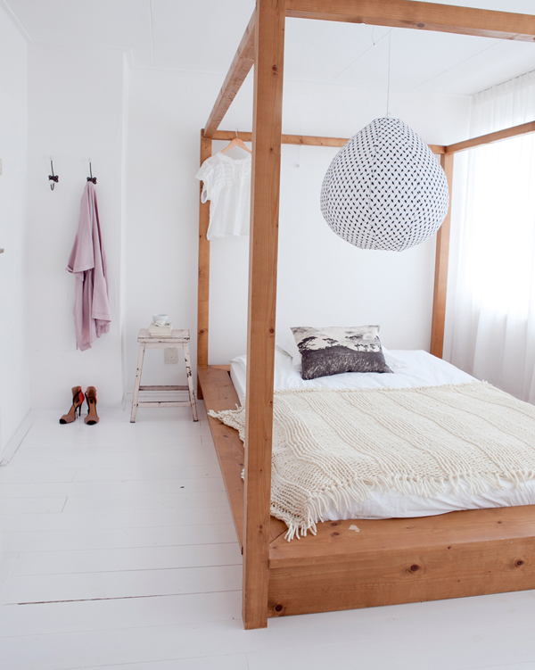 Witte frisse slaapkamer met houten hemelbed