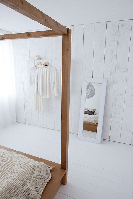 Witte houten vloer en houten planken aan de muur in slaapkamer