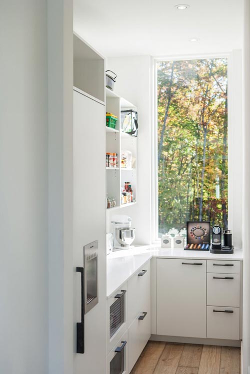 Smalle bijkeuken met raam en witte kasten Smalle bijkeuken met raam en witte kasten